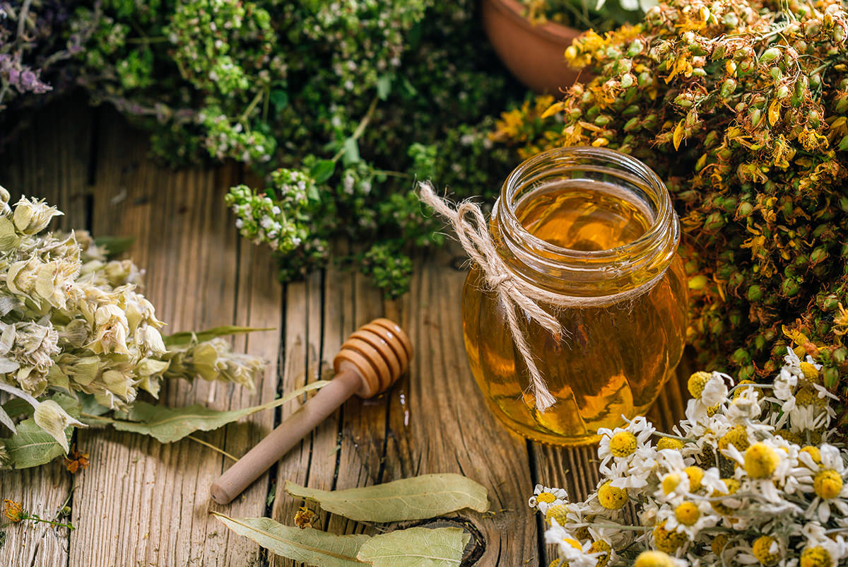 Flower honey in a glass jar, harvesting wild medicinal herbs